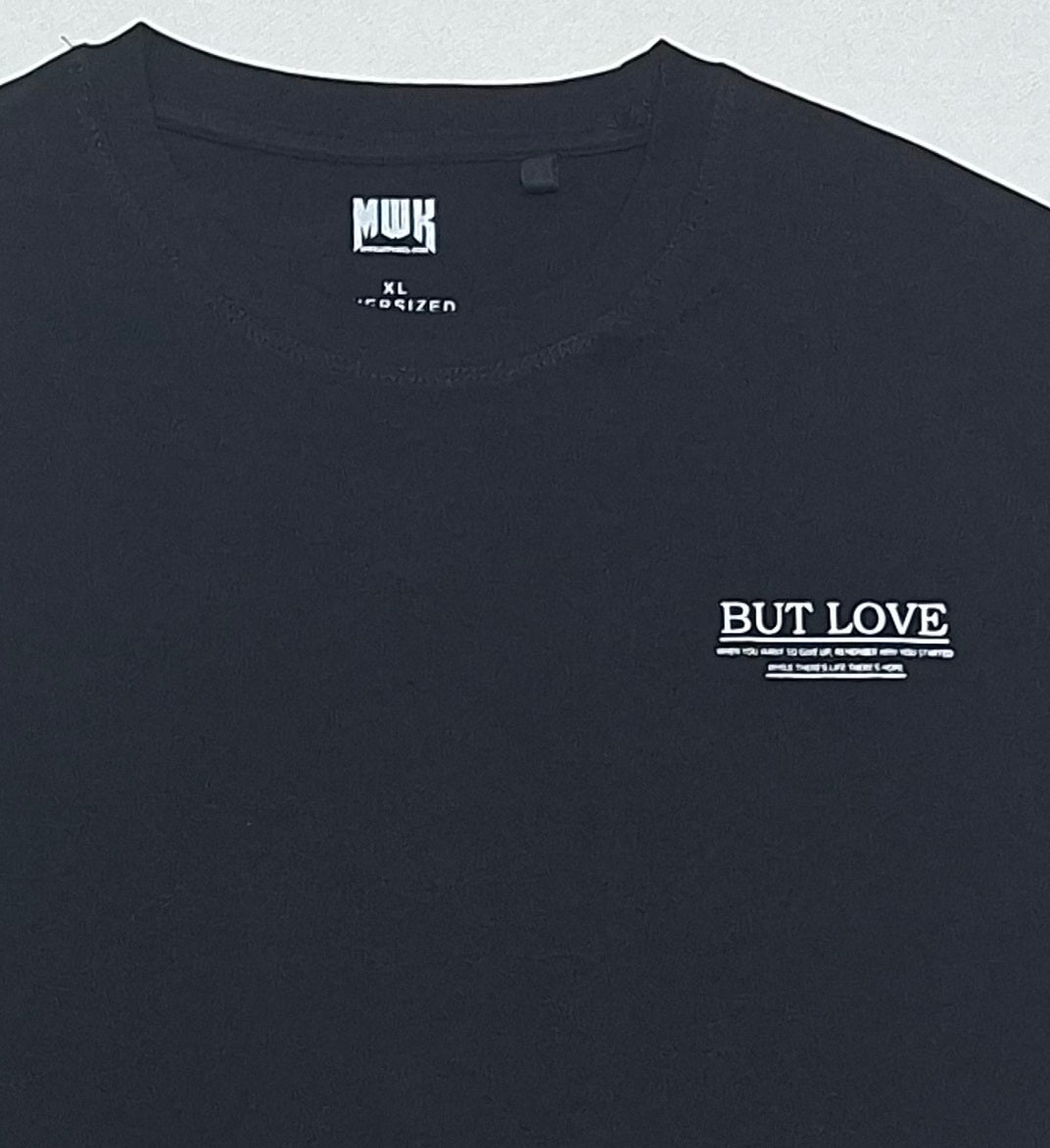 Men's Black oversized T-shirt featuring a "No Money But Love" floral and butterfly graphic print on the back.