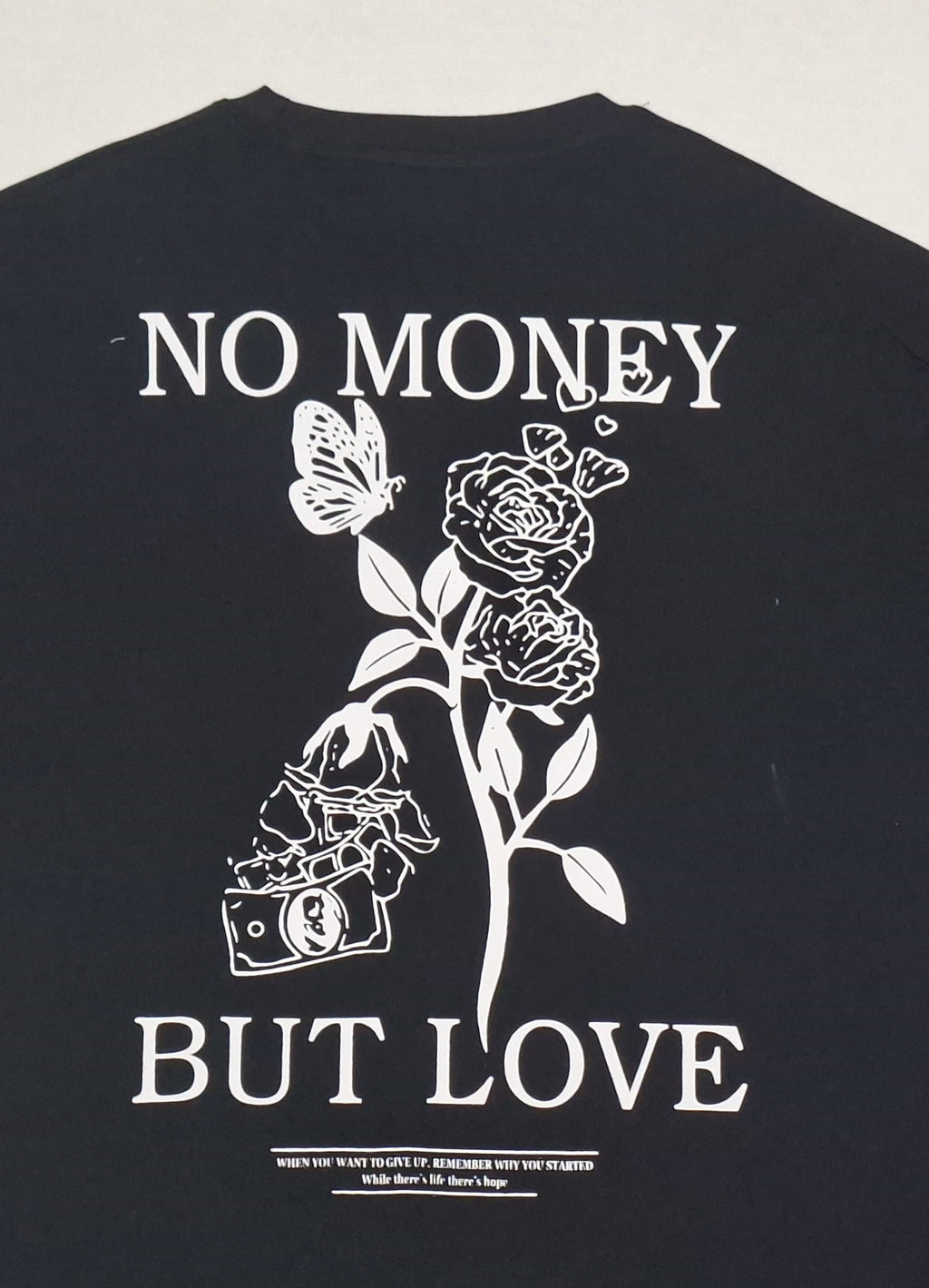 Men's Black oversized T-shirt featuring a "No Money But Love" floral and butterfly graphic print on the back.