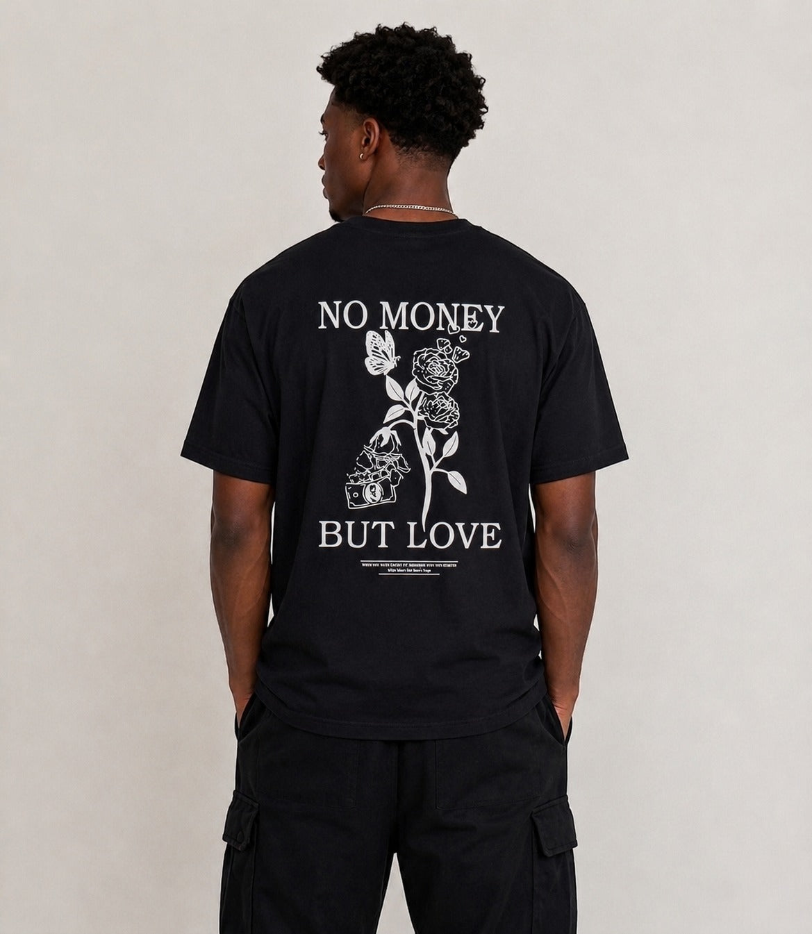 Men's Black oversized T-shirt featuring a "No Money But Love" floral and butterfly graphic print on the back.